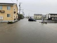 冠水して路面が見えなくなった道路とビニールハウス。