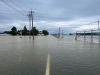 冠水して路面が見えなくなった道路とビニールハウス。