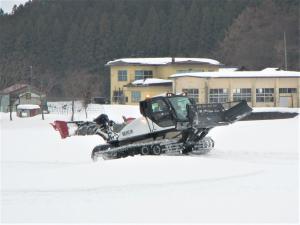 圧雪車に乗り、索道員による運転を楽しんでいる様子です。